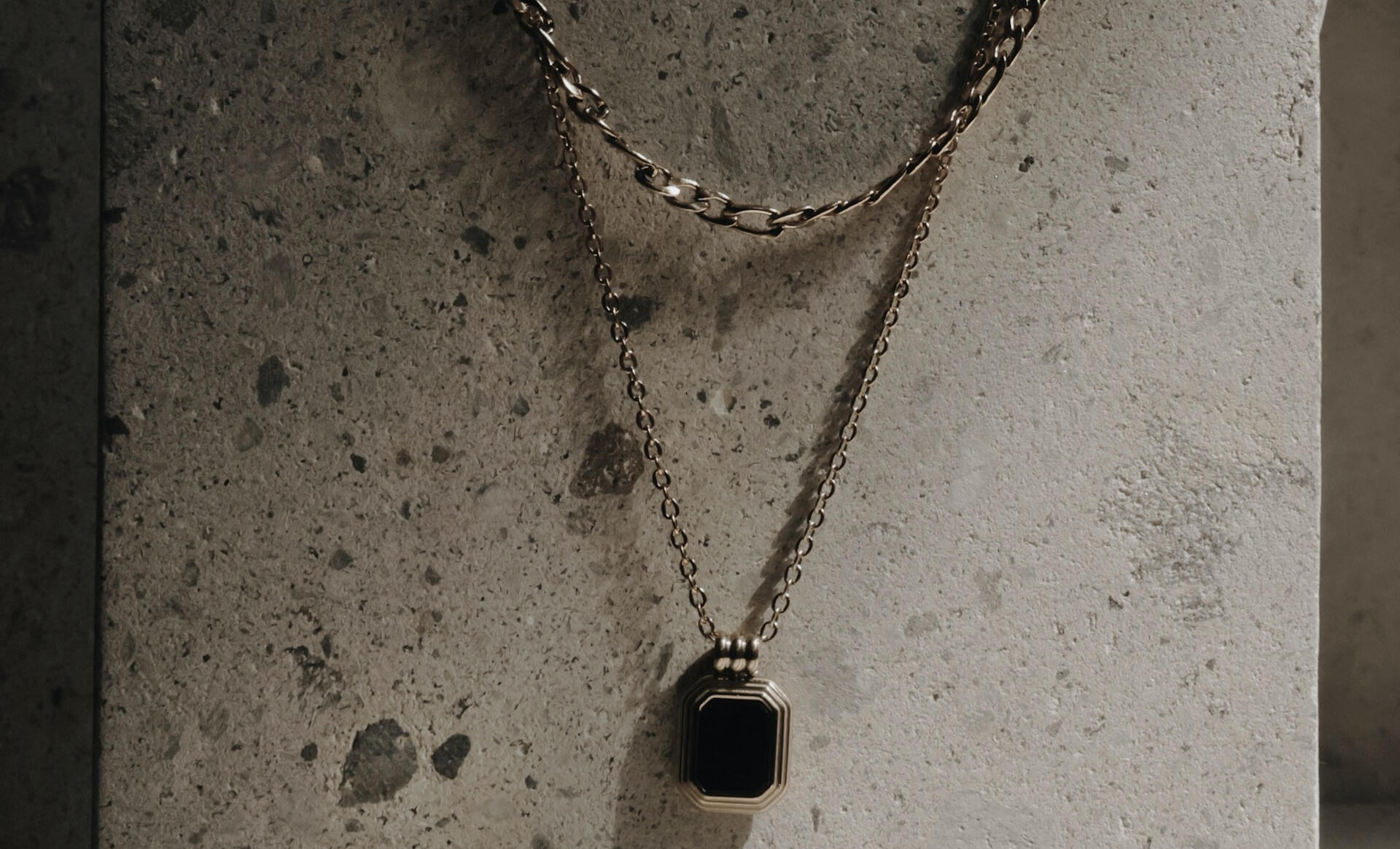 sterling silver necklaces on concrete wall